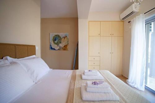 a bedroom with a white bed with towels on it at KYPARISSIA LUXURY HOME in Kyparissia