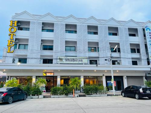 a hotel with two cars parked in front of it at Keeree Boutique Hotel in Phetchaburi
