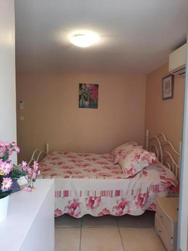 Cette petite chambre comprend un lit avec des draps roses. dans l'établissement CHAMBRE LEUCATE VILLAGE, à Leucate