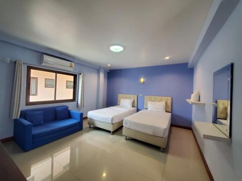 um quarto com uma cama e uma parede azul em Keeree Boutique Hotel em Phetchaburi