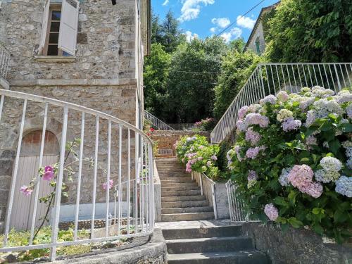 un escalier avec des fleurs sur le côté du bâtiment dans l'établissement La Dolce Vita Camille, à Vals-les-Bains