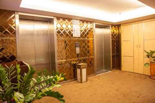 a elevator lobby in a building with gold tiles at Fuhao Hotel in Guangzhou