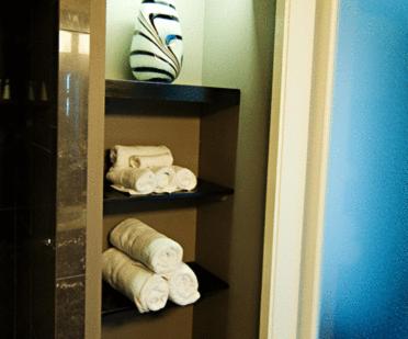 a shelf with rolled towels in a bathroom at Oyster Point Hotel in Red Bank