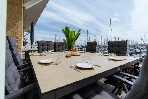 a table with plates and utensils on top of a marina at Kabbelaarsbank 2C - Port Marina Zélande in Ouddorp