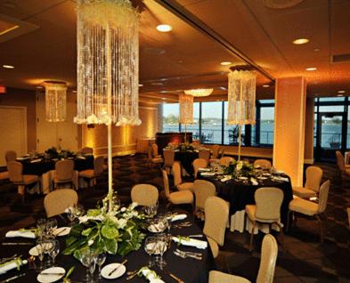 uma sala de banquetes com mesas, cadeiras e lustres em Oyster Point Hotel em Red Bank