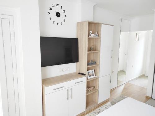 een woonkamer met een tv aan de muur bij Apartment SUNSET in Trebinje