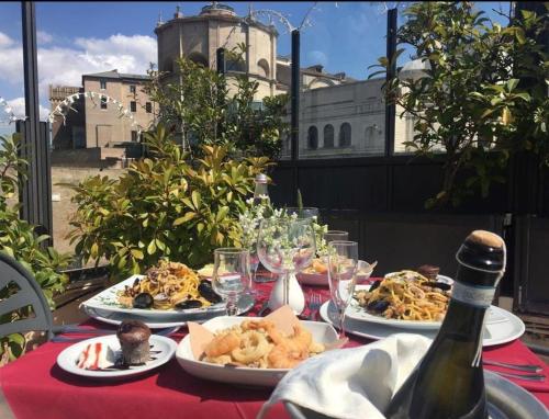 a table with plates of food and a bottle of wine at Tmark Hotel Vaticano in Rome