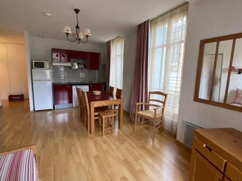 une cuisine et un salon avec une table et des chaises dans l'établissement Bagnères de Luchon, Résidence Val de Jade, Beau T3 meublé, plein centre, pour 4 ou 6 personnes, à Luchon