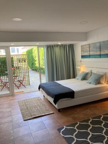 a bedroom with a bed and a balcony at Beautiful Boutique House Near the Beach in Costa da Caparica