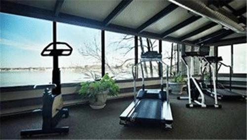 a gym with two machines and a large window at Oyster Point Hotel in Red Bank