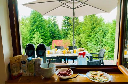 a table with plates of food and an umbrella at FlowMove Retreat Kamesznica in Kamesznica