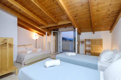 a bedroom with two beds and a balcony at Amazing View Family Penthouse in Nafplio