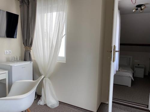 a door leading to a bedroom with a white curtain at Boutique Rooms with Parking in Oradea