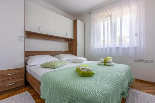 een slaapkamer met 2 bedden en handdoeken bij Apartments Rogić in Crikvenica