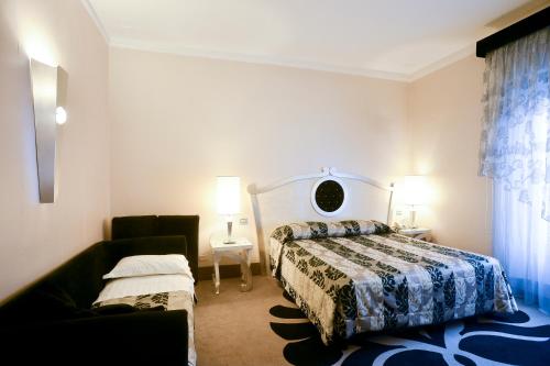 a bedroom with a bed and a couch at Zanhotel Tre Vecchi in Bologna