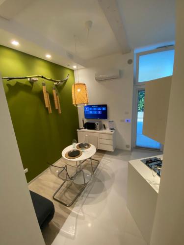 cocina con mesa y pared verde en Home3 beb appartments, en Bisceglie