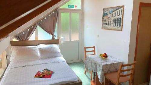 a bedroom with a bed and a small table with a table at Laura Studio Apartman in Mlini