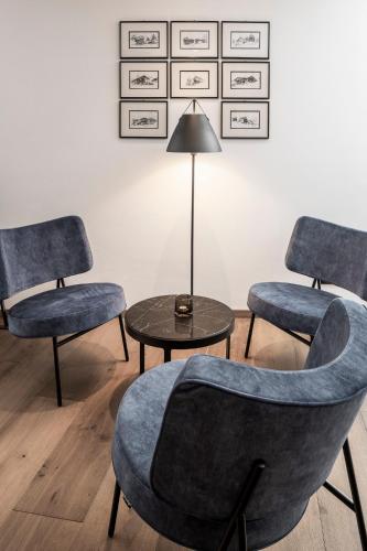 a room with three chairs and a table and a lamp at Linder Cycling Hotel in Selva di Val Gardena