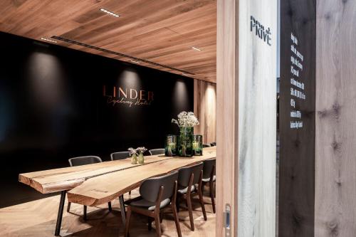a long wooden table and chairs in a room at Linder Cycling Hotel in Selva di Val Gardena