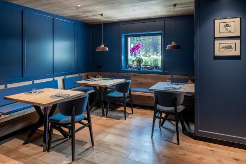 a dining room with blue walls and tables and chairs at Linder Cycling Hotel in Selva di Val Gardena