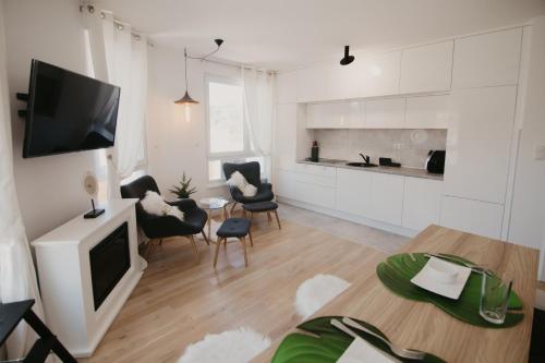 a living room with a television and a table and chairs at Akro Studio apartman in Tuzla