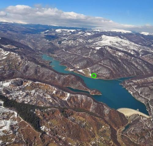 an aerial view of a lake in the mountains at Luxury Lake House & Glamping in Teşila