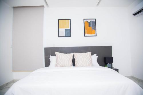 a bedroom with a large white bed with pillows at MiVi - Midtown Victoria Island in Lagos