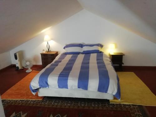a bedroom with a bed with blue and white stripes at Cozy Country House near Beaches in Azoia