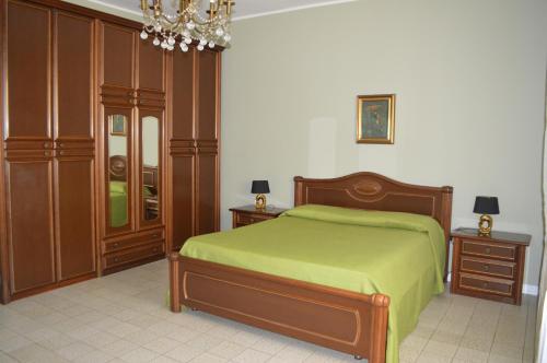 una camera con letto verde e mobili in legno di Gallipoli Apartment ActiveLife a Gallipoli