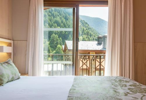 a bedroom with a bed and a large window at Hotel Princesa Parc in Arinsal