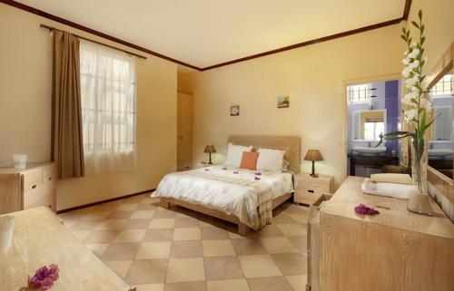 a large bedroom with a bed and a bathroom at Talamba Blue in Blue Bay