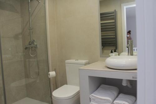 uma casa de banho com um chuveiro, um WC e um lavatório. em AT La casa Azul em Cuenca
