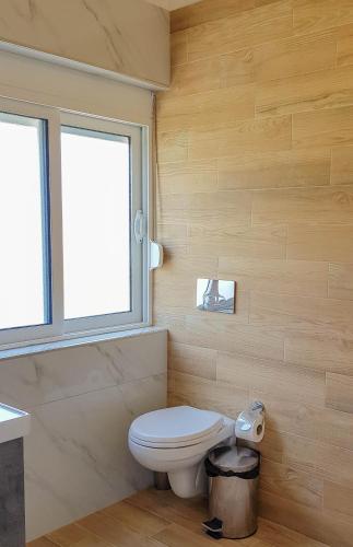 a bathroom with a toilet and a window at Villa Goliku in Peshtan