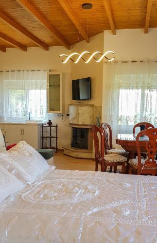 a bedroom with a bed and a table and a fireplace at Villa Goliku in Peshtan
