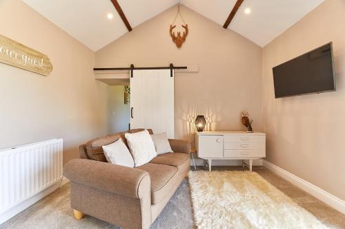 a living room with a couch and a tv at Host & Stay - The Pepper Pot in Alnwick