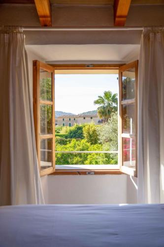a bedroom with a bed and a window at Finca Ca'n Quatre in Sóller