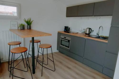 une cuisine avec une table et des tabourets dans l'établissement Petit loft sur les toits d'Avignon, à Avignon