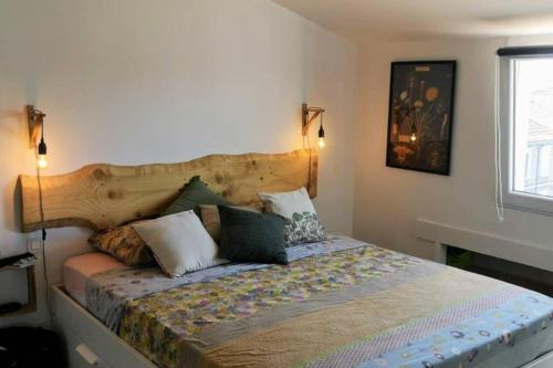 une chambre avec un lit avec une tête de lit en bois dans l'établissement Petit loft sur les toits d'Avignon, à Avignon