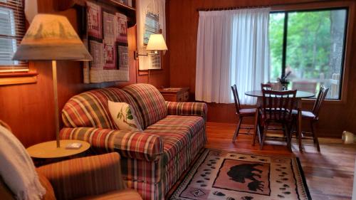 a living room with a couch and a table at Cozy Creek Cottages in Maggie Valley