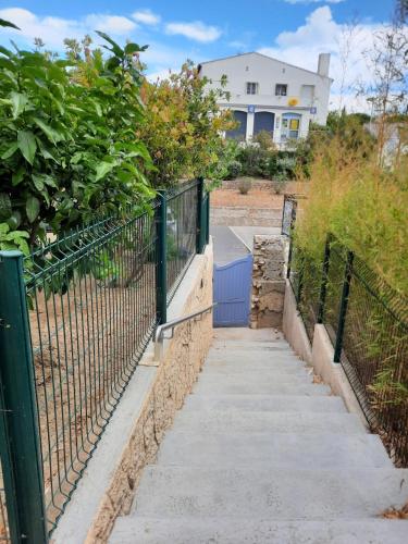 a fence next to a sidewalk in front of a house at CHAMBRE LEUCATE VILLAGE in Leucate