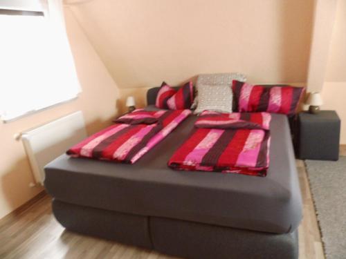 a black bed with two pillows on it in a room at Hotel Restaurant Zum Valwiger Herrenberg in Valwig