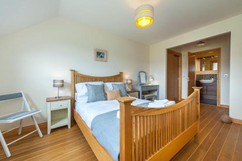 a bedroom with a wooden bed and a desk at Lazy Puffin in Stonehaven