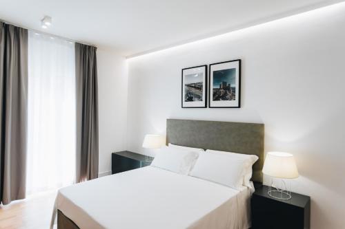 sypialnia z białym łóżkiem i oknem w obiekcie Centoquindici Rooms & Suite w mieście Montesilvano