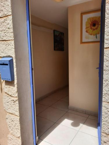 un couloir avec une porte menant à une chambre avec un miroir dans l'établissement CHAMBRE A LEUCATE VILLAGE, à Leucate