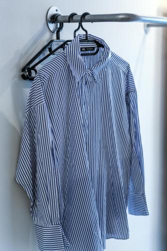 a blue and white shirt hanging on a rack at Unique Experience Apartment’s in Thessaloniki