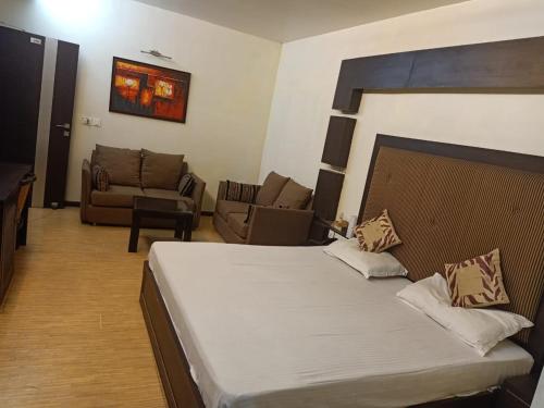 a bedroom with a bed and a living room at Hotel V.I.P. Regency in Dhanbād
