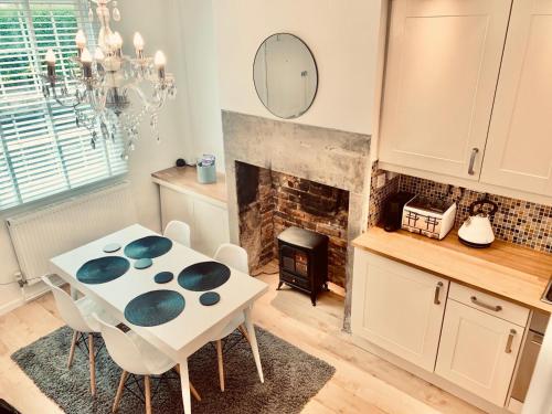 a kitchen with a table and chairs and a fireplace at The Tenth House, Grade II Listed Georgian Town House, Wirksworth, Derbyshire, Peak District Cottage, Sleeps 4 in Wirksworth