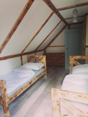 two beds in a room with a attic at Domek Na Gwizdówce " u KARGULA" - KASZUBY in Sierakowice