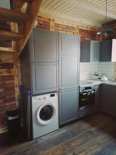 a kitchen with a washing machine and a washer at Domek Na Gwizdówce " u KARGULA" - KASZUBY in Sierakowice