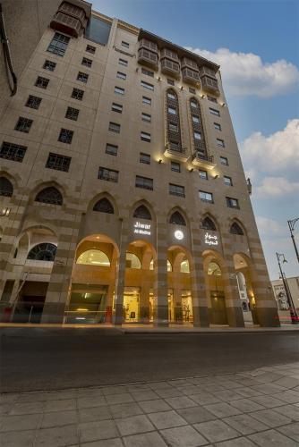 a large building with windows on a city street at Jiwar Al Madina Hotel in Al Madinah